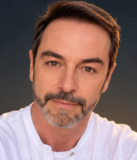 Francisco Sanz con camisa blanca, iluminado por una luz cálida